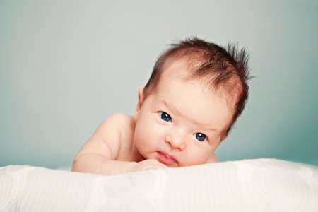 Newborn girl lies on a knitted blanketの写真素材