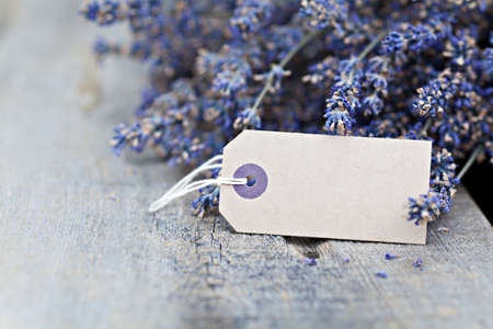Dried lavender flowers with blank paper tag on wooden backgroundの写真素材
