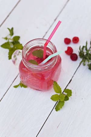 Cold raspberries drink in glass jar on white backgroundの写真素材
