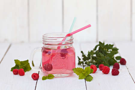 Cold raspberries drink in glass jar on white backgroundの写真素材