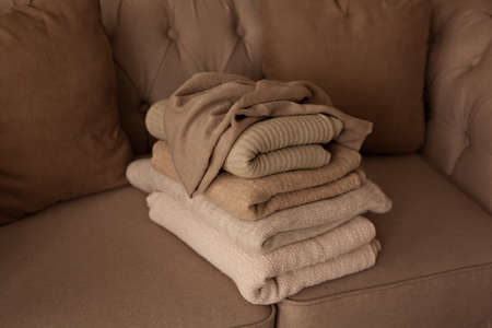 Pile of wool beige fabrics on sofa