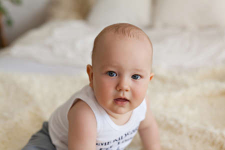 Cute happy 7 month baby boy in bed