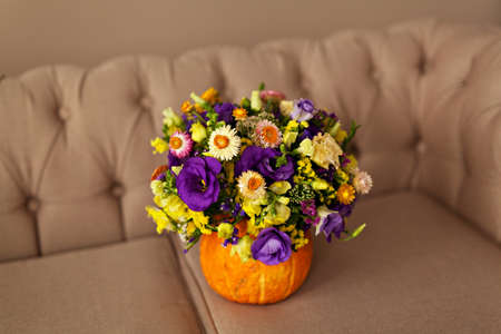 Autumn floral bouquet in a pumpkin vase for Halloweenの写真素材