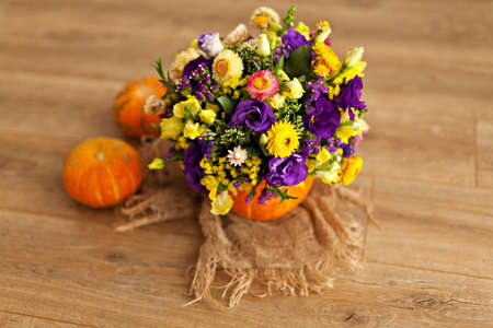 Autumn floral bouquet in a pumpkin vase for Halloweenの写真素材