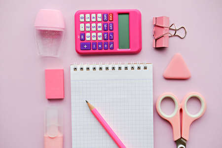 Pink girlish school supplies, notebooks and pens on pink background. Top view, flat lay. Copy space. Back to school.の写真素材