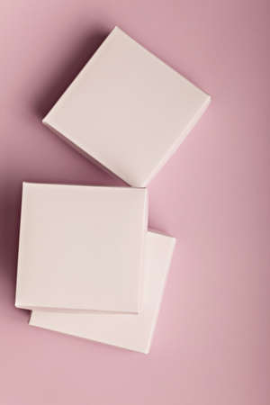 Stack of white cardboard boxes on a pink background with copyspace for your textの写真素材