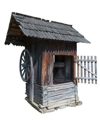 Old water well with a roof covered with shingles isolated on white backgroundの写真素材