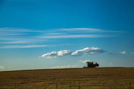Harvester gathers the agricultural harvest from the fieldsの写真素材