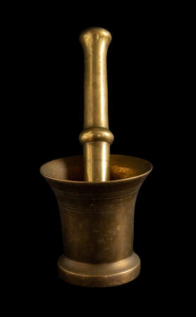 Old brass mortar - a vessel for grinding products isolated on a black backgroundの写真素材