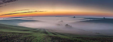 Morning sunrise over a misty valleyの写真素材