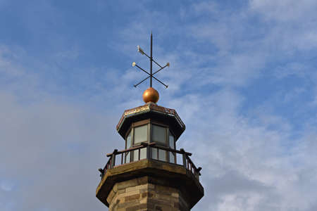 A weather vane on top of a stone tower.