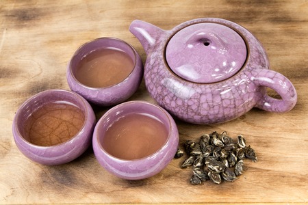 Kettle and cups of tea and next a handful of spilled tea