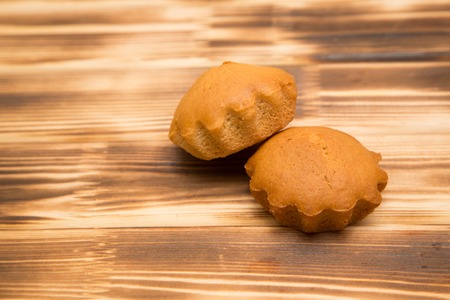 Two homemade muffins on a wooden Boardの写真素材