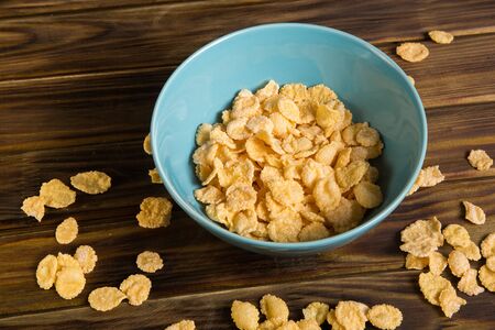 Cornflakes in a Cup for Breakfast on a wooden table