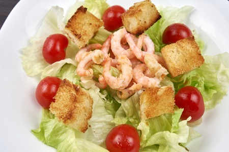 Caesar salad with shrimp on white plateの写真素材