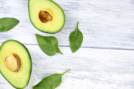 Slices of avocado on white background. Whole and half with leaves.の写真素材