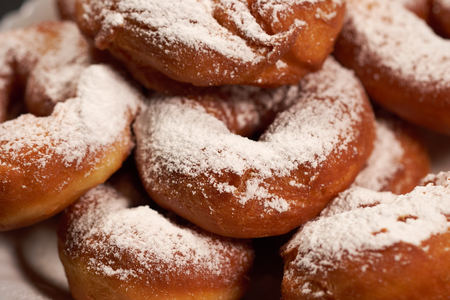 doughnuts sprinkled with powdered sugar on a white plateの写真素材