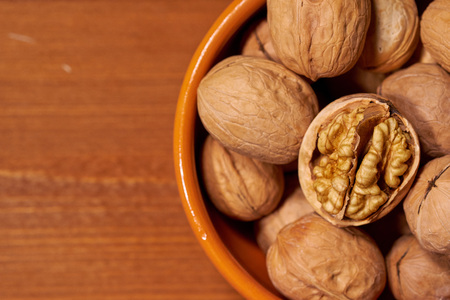 Walnut on brown wooden background.