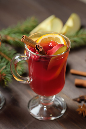 Mulled wine on a wooden background with candles, pine branches and Christmas lights.の写真素材