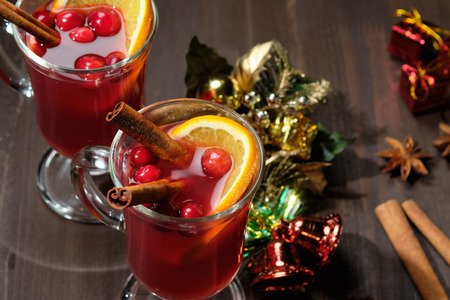 Mulled wine on a wooden background with candles, pine branches and Christmas lights.の写真素材