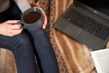 woman with a Cup of tea, a book, a laptopの写真素材