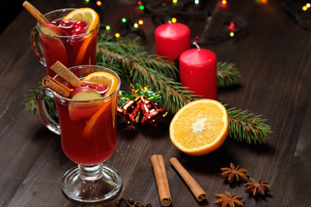 Mulled wine on a wooden background with candles, pine branches and Christmas lights.の写真素材