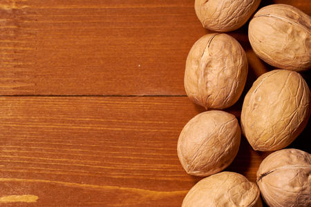 Walnut on brown wooden background.