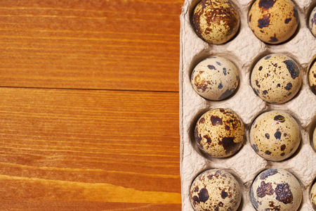 Quail eggs s in lattice on brown wooden backgroundの写真素材