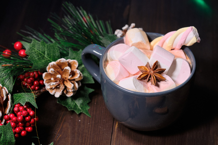 marshmallow in grey cup on brown wood background with Christmas tree ,  candles and christmas lights. Close upの写真素材