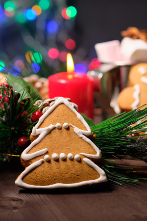 ginger biscuit  and marshmallow on brown background with Christmas tree ,  candles and christmas lights. Close upの写真素材