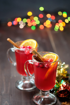 Mulled wine on a wooden background with candles, pine branches and Christmas lights.の写真素材