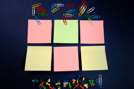 colored paper clips, button and stickers   on a dark blue background. Close upの写真素材