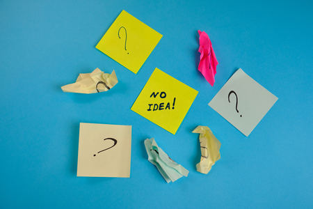 crumpled colored blank stickers with the inscription no ideas on a blue background.  Close up