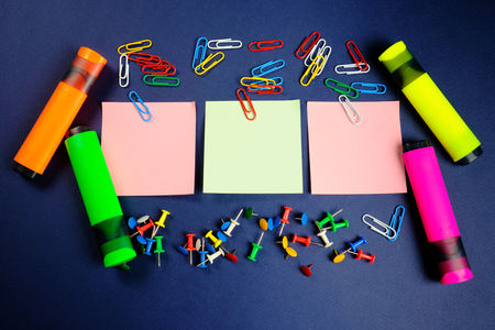 colored paper clips, button, markers and stickers   on a dark blue background. Close upの写真素材