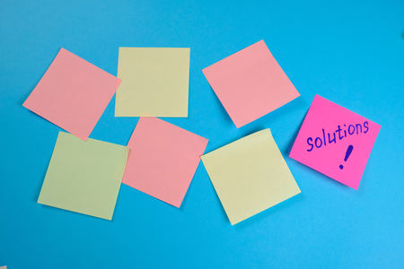 Mock-up many colored empty office stickers on a blue background and one separately . Close upの写真素材