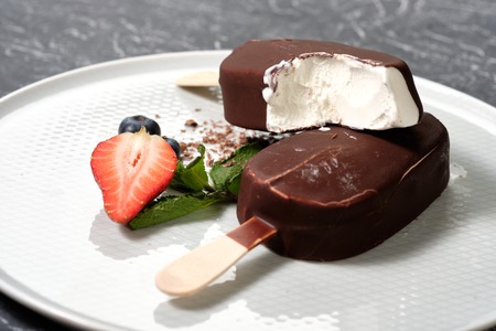 chocolate butter ice cream on the white plate with fresh summer berries, strawberries, blueberries Grey backgroundの写真素材