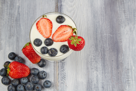 Strawberry, blueberry with yogurt on wooden backgroundの写真素材