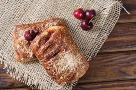 Puff pastry with red cream on the wooden board.の写真素材