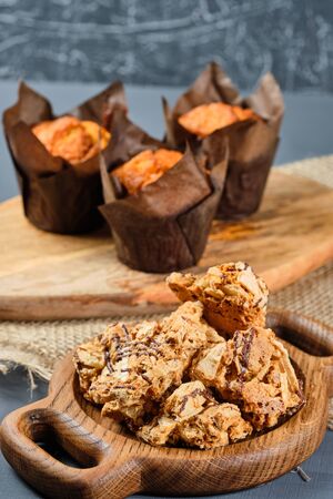 caramel waffles on a wooden plate and cupcakes on a gray background. Rustic styleの写真素材