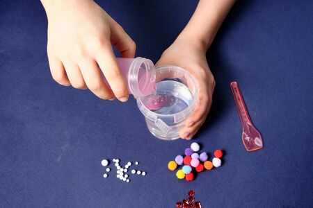 We make slime at home. making popular children's toys from glue.. Children's hands make a toy out of slime onの写真素材