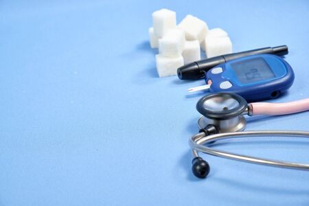 The glucometer with the test strip on a blue background.の写真素材