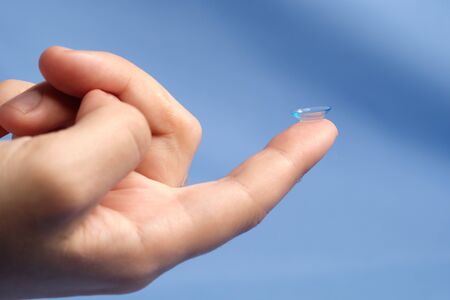 Contact lenses on the fingertip on a blue background,の写真素材