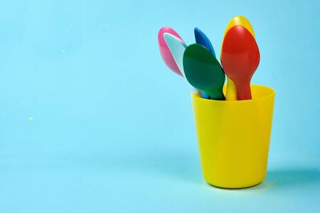 Multicolored plastic dishes on a blue background. The concept of environmental pollution by plastic, ecology. place for text,の写真素材
