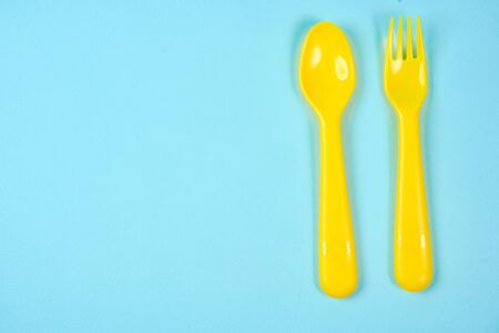 Multicolored plastic dishes on a blue background. The concept of environmental pollution by plastic, ecology. place for text,の写真素材