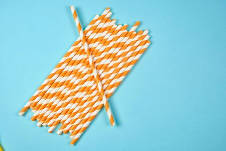 Plastic tubes for drinks on a blue background. The concept of environmental pollution by plastic,...