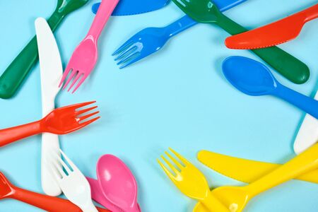 Multicolored plastic dishes on a blue background. The concept of environmental pollution by plastic, ecology. place for text,の写真素材