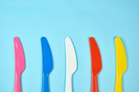 Multicolored plastic dishes on a blue background. The concept of environmental pollution by plastic, ecology. place for text,の写真素材