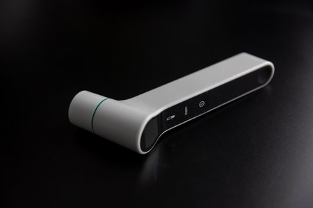 Infrared digital thermometer on black background, modern smart healthcare device for measuring body temperature.の写真素材