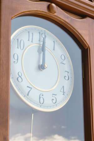 Antique clock with reflection of blue sky and cloudsの写真素材