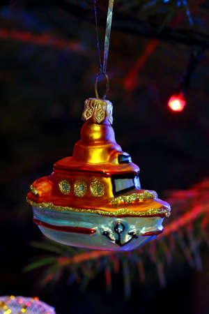 Christmas toys in the form of a ship in the light of lamps garlandsの写真素材